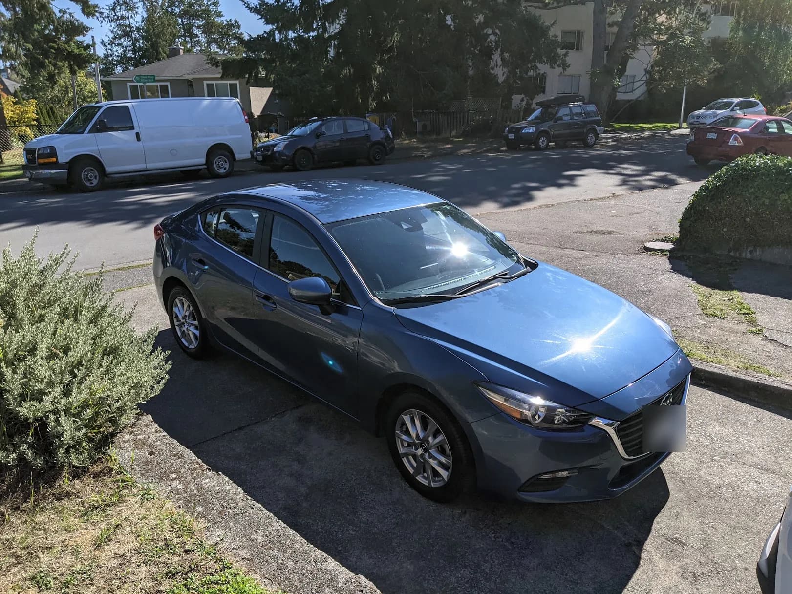 A blue Mazda 3 parked in our driveway the day I brought it home